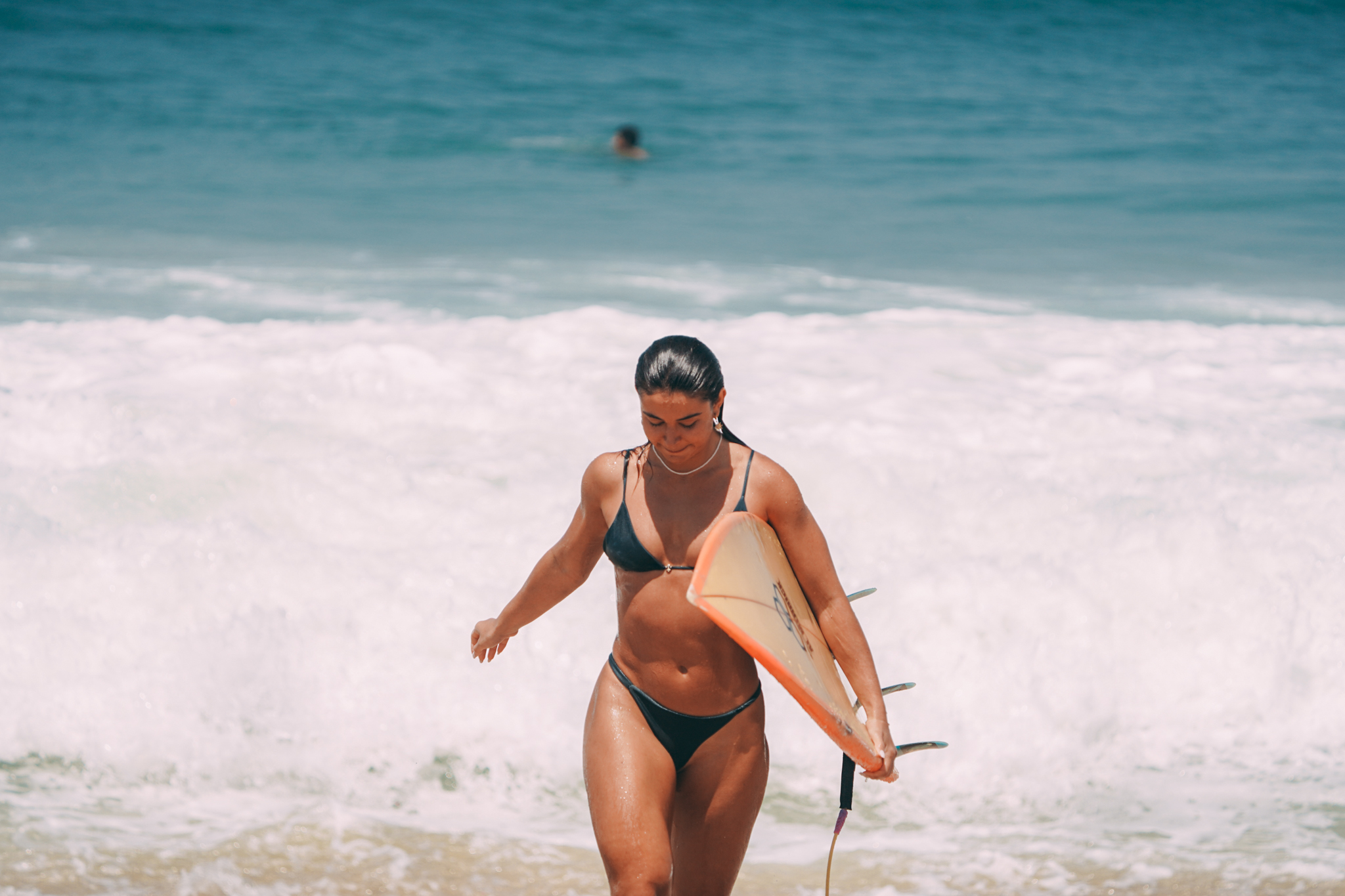 Surfista saindo do mar com sua prancha