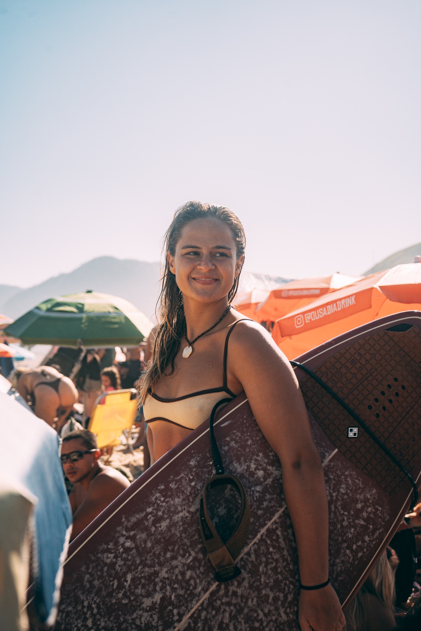 Surfista sorrindo com sua prancha na praia